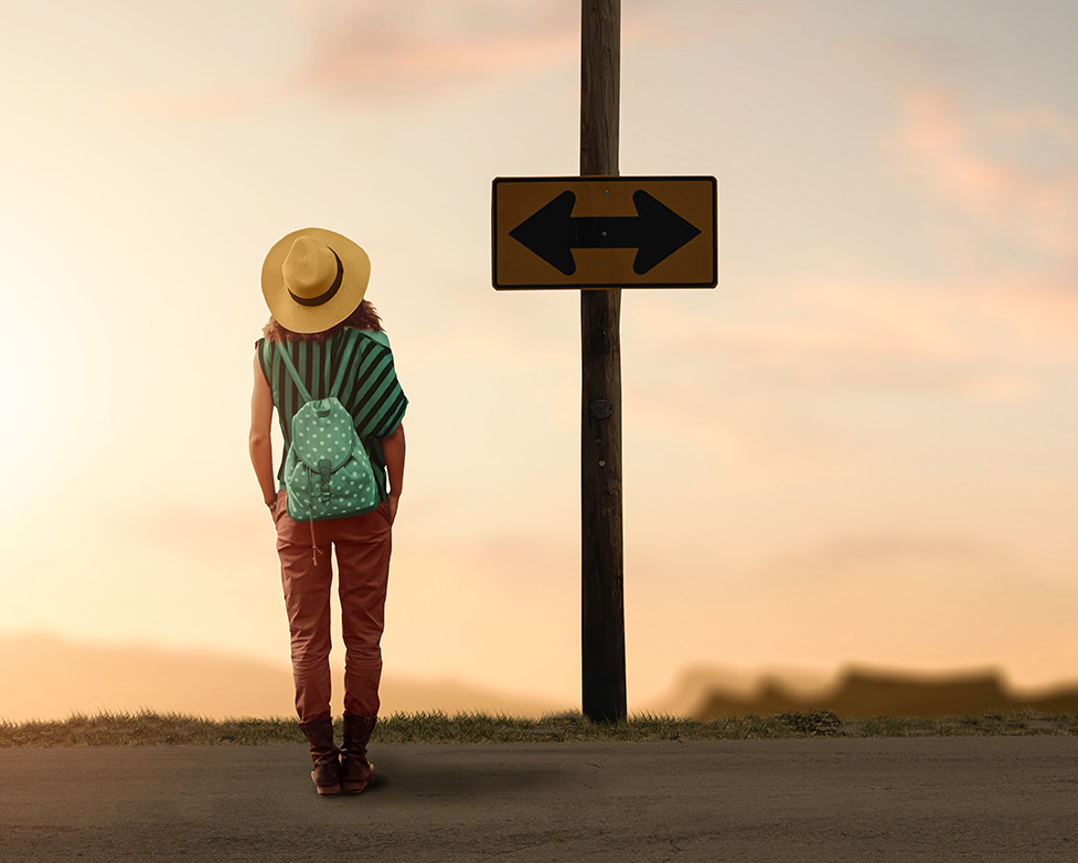 Woman standing at a crossroads trying to choose a path. Work with therapist Deborah Kourgelis to find guidance on your journey.