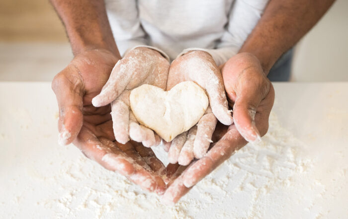 Adult holding child's hands while baking cookies - how to overcome adverse childhood experiences (ACEs)