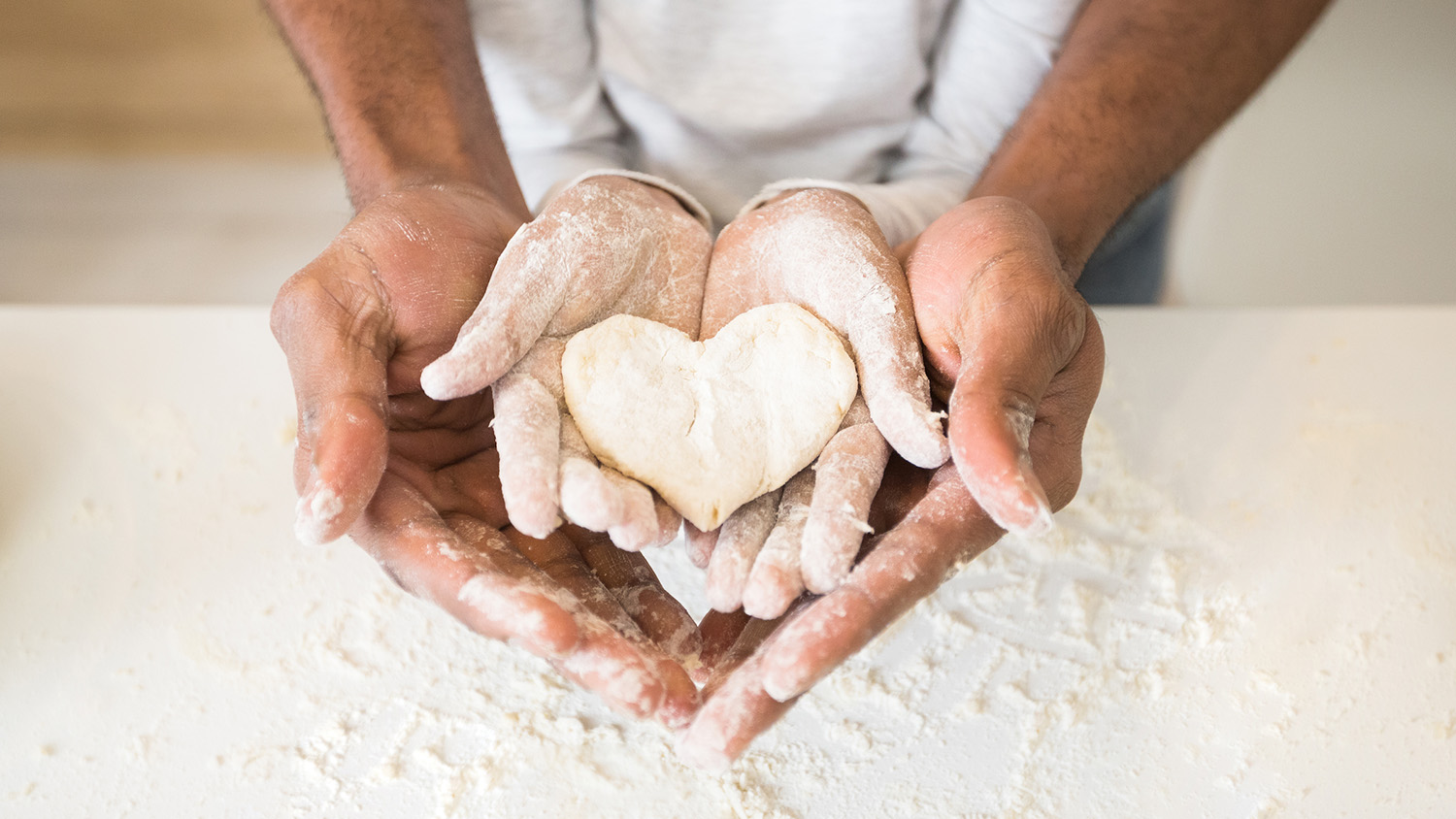 Adult holding child's hands while baking cookies - how to overcome adverse childhood experiences (ACEs)